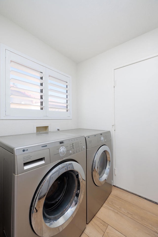 washroom with light wood-type flooring and independent washer and dryer