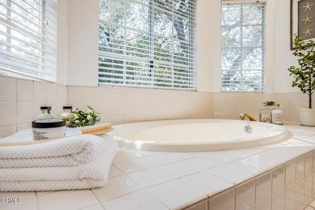 bathroom featuring a relaxing tiled tub and tile patterned floors