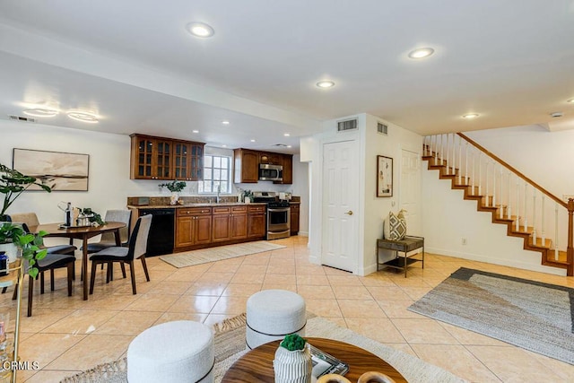 kitchen with stainless steel appliances, sink, and light tile patterned floors