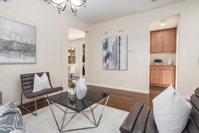 living room featuring dark wood-type flooring and an inviting chandelier