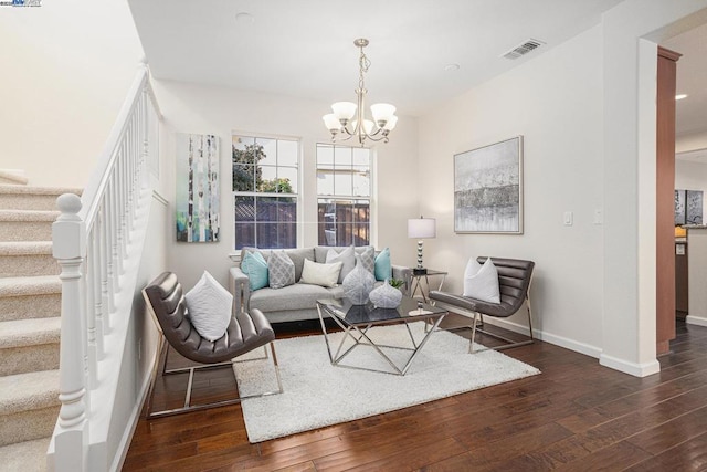 living room with dark hardwood / wood-style floors and an inviting chandelier