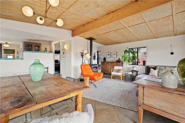 living room featuring lofted ceiling with beams, a wood stove, and wood ceiling