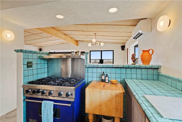 kitchen featuring stainless steel stove, tasteful backsplash, vaulted ceiling with beams, tile counters, and a wall unit AC