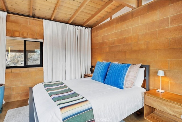 bedroom featuring lofted ceiling with beams, wooden ceiling, and concrete floors