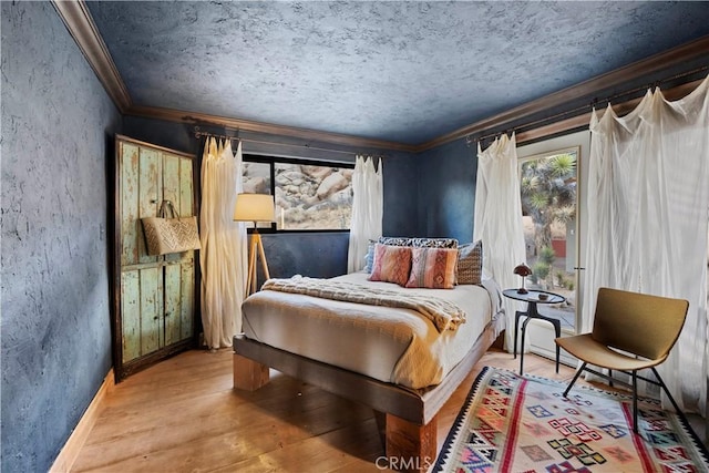 bedroom with ornamental molding, hardwood / wood-style floors, and a textured ceiling