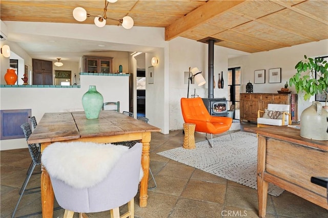 dining room with wooden ceiling, lofted ceiling with beams, and a wood stove