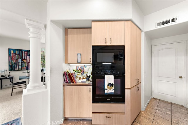 kitchen featuring light tile patterned floors, light brown cabinets, built in microwave, oven, and ornate columns