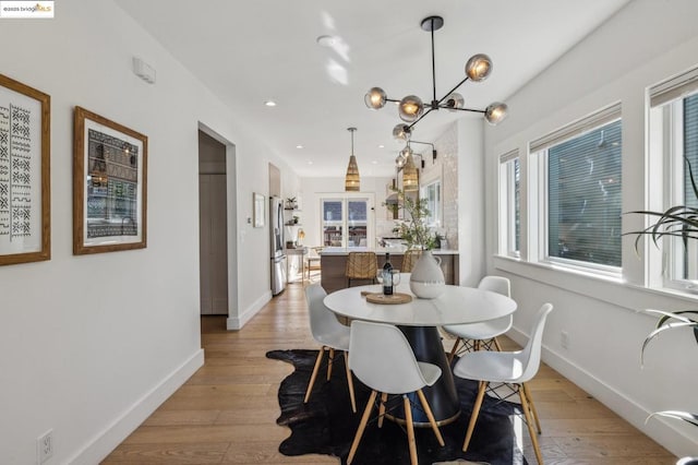 dining area featuring an inviting chandelier and light hardwood / wood-style floors