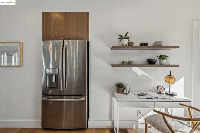 kitchen with stainless steel fridge and light hardwood / wood-style floors