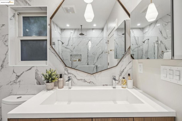 bathroom with walk in shower, vanity, toilet, and tile walls