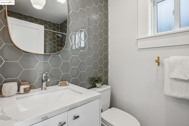 bathroom with vanity, toilet, tile walls, and backsplash