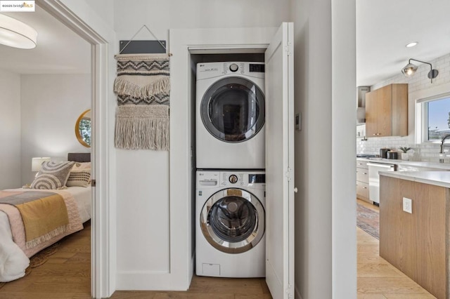 washroom featuring light wood-type flooring and stacked washing maching and dryer