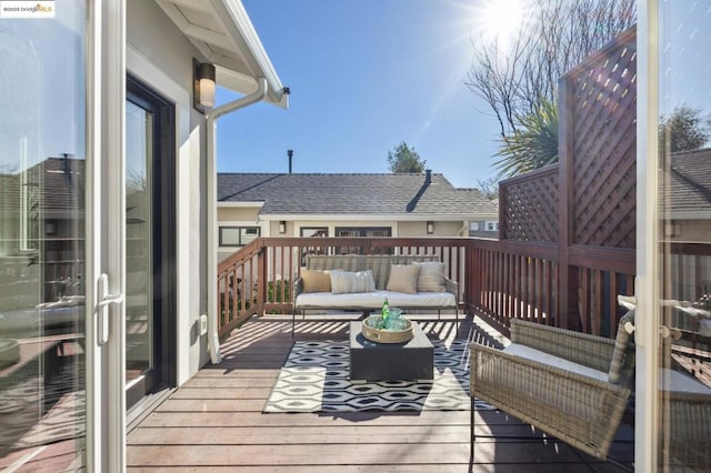 wooden terrace with an outdoor living space