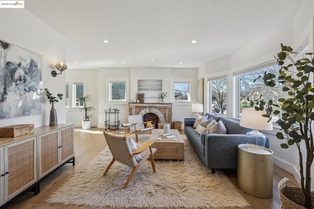 living room with a brick fireplace and light hardwood / wood-style flooring