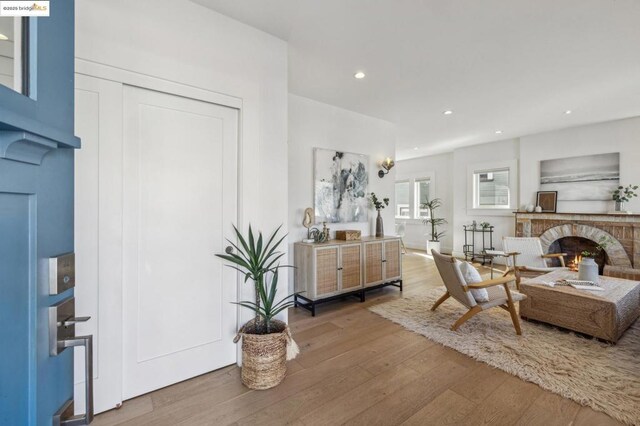 interior space with a brick fireplace and hardwood / wood-style flooring