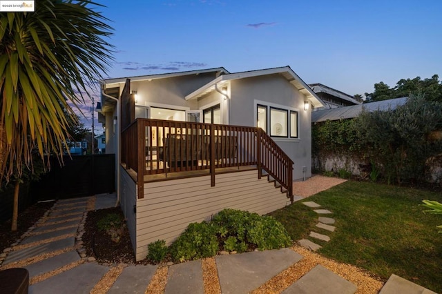 exterior space with a deck and a lawn