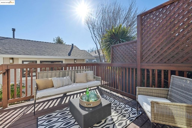 wooden terrace with an outdoor living space