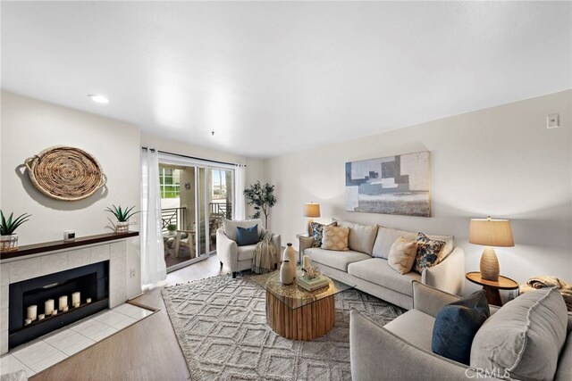 living room with a tiled fireplace and light hardwood / wood-style flooring