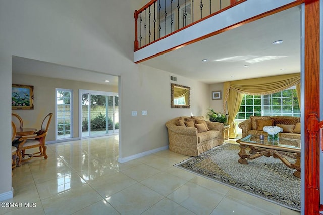 living room featuring a towering ceiling and light tile patterned floors