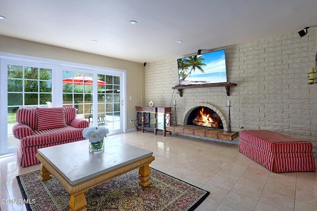 living room featuring light tile patterned floors, a fireplace, and brick wall