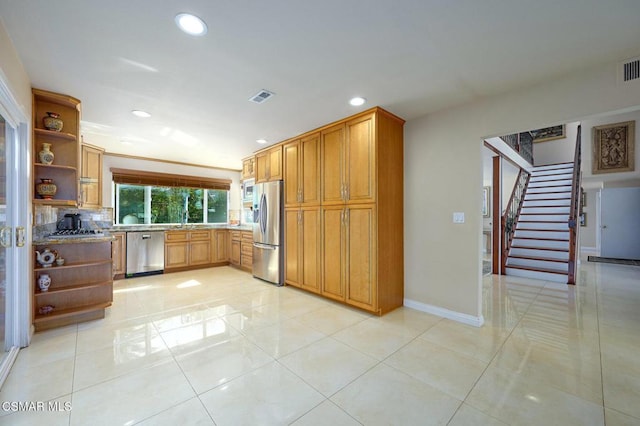 kitchen with appliances with stainless steel finishes, light tile patterned floors, and backsplash