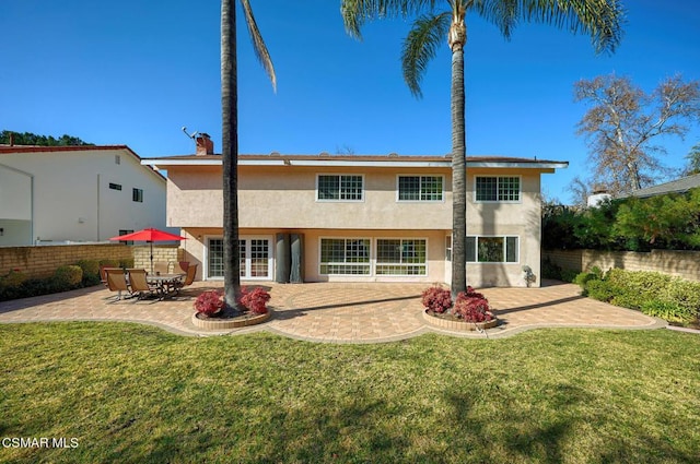 rear view of house featuring a patio area and a lawn