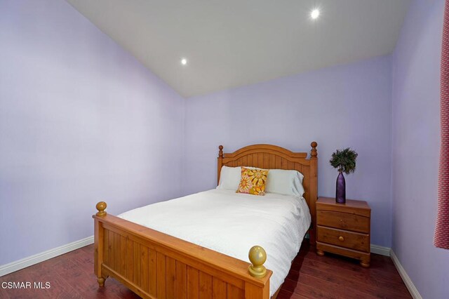 bedroom with vaulted ceiling and dark hardwood / wood-style flooring