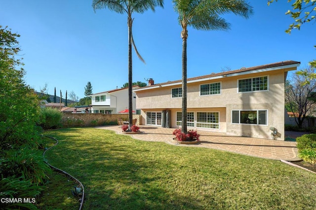 rear view of house with a yard and a patio