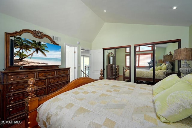 bedroom featuring lofted ceiling and two closets