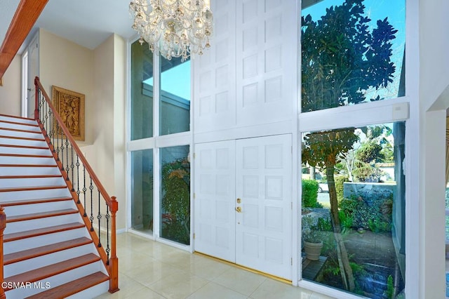 tiled foyer entrance with a notable chandelier