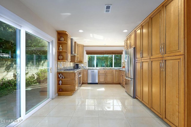 kitchen with appliances with stainless steel finishes, light stone countertops, decorative backsplash, and light tile patterned floors