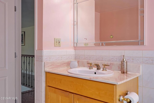 bathroom with vanity and tile walls