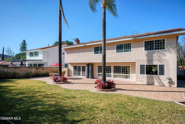 back of house with a yard and a patio area