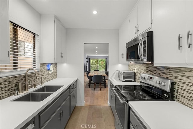 kitchen featuring stainless steel appliances, sink, and white cabinets