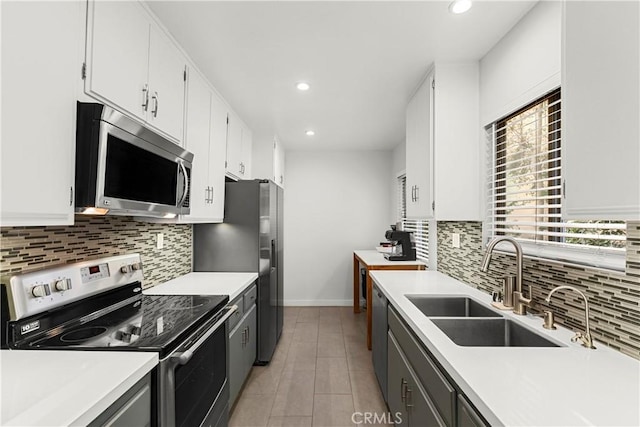 kitchen featuring sink, light tile patterned floors, white cabinets, and appliances with stainless steel finishes