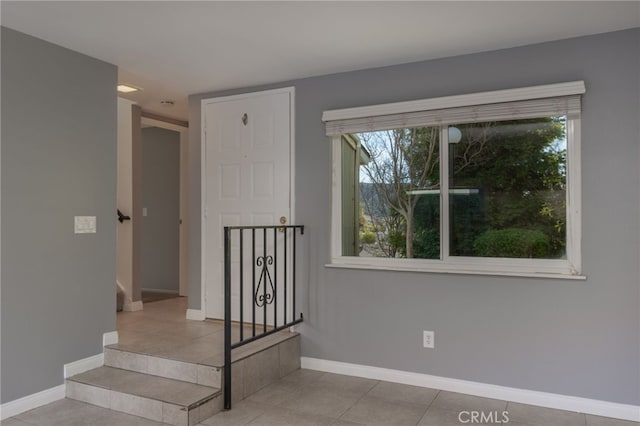 stairway with tile patterned floors and a healthy amount of sunlight