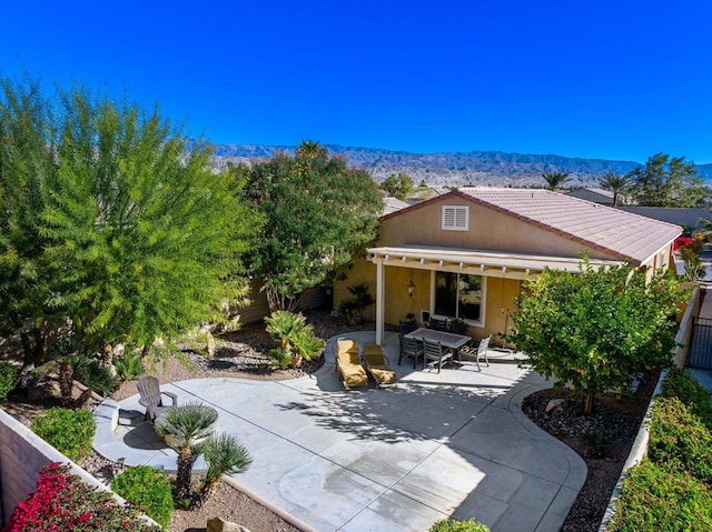 back of house featuring a mountain view and a patio area