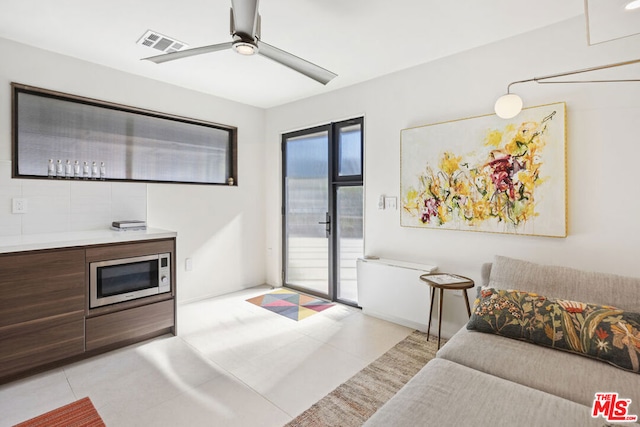 tiled living room featuring ceiling fan