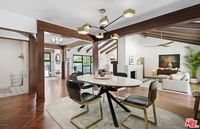 dining space featuring parquet floors, ceiling fan with notable chandelier, and vaulted ceiling with beams