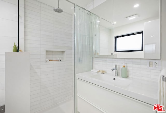 bathroom featuring tasteful backsplash, vanity, and an enclosed shower