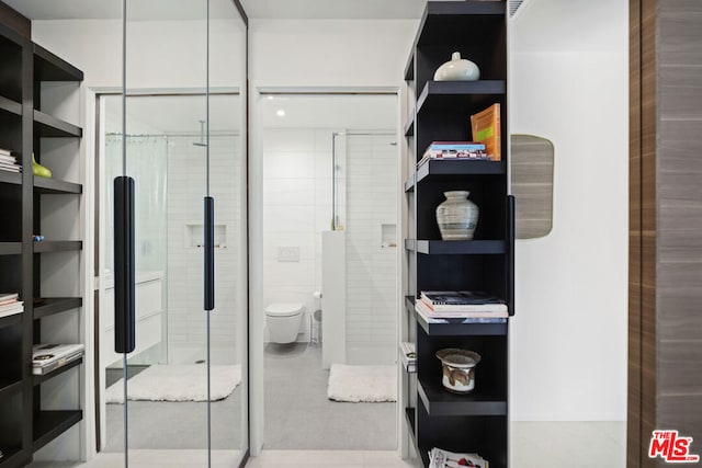 walk in closet with light tile patterned floors