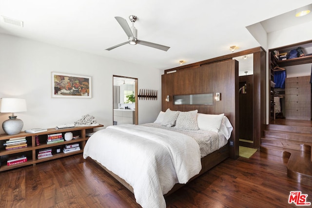 bedroom featuring ceiling fan, connected bathroom, dark hardwood / wood-style flooring, and a closet