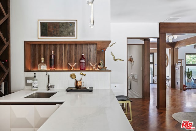 kitchen with pendant lighting, sink, tasteful backsplash, and dark parquet floors