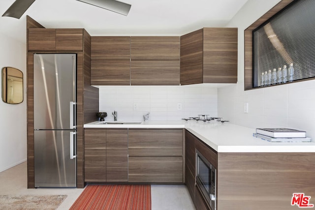 kitchen with stainless steel appliances, sink, and decorative backsplash