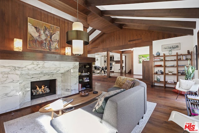 living room featuring wooden walls, a fireplace, dark hardwood / wood-style flooring, and vaulted ceiling with beams