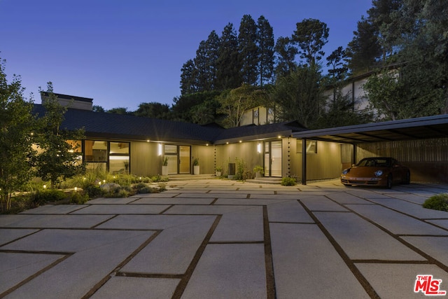 back house at dusk with a carport