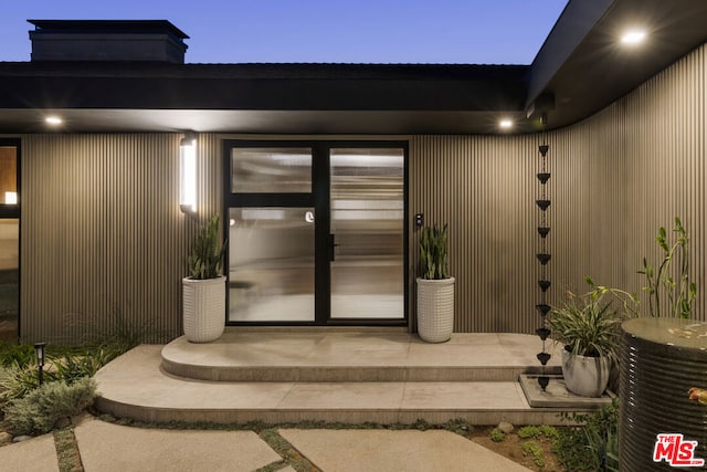 exterior entry at dusk featuring a patio area