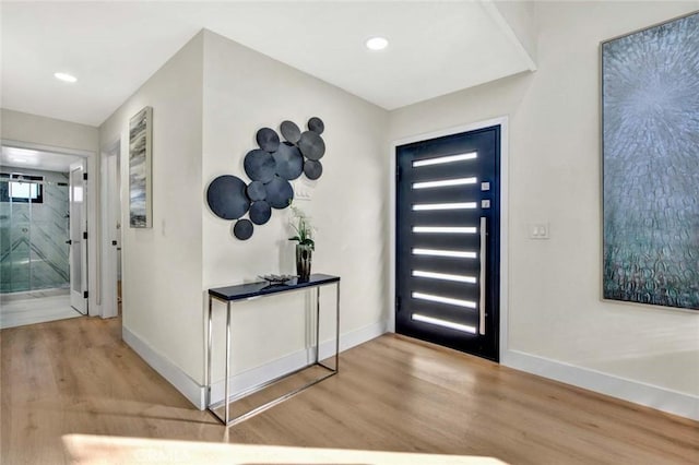 entryway featuring baseboards, wood finished floors, and recessed lighting