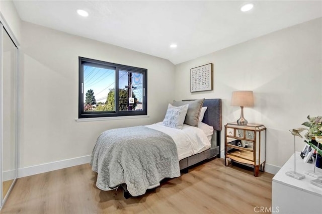 bedroom with light wood-type flooring, a closet, baseboards, and recessed lighting