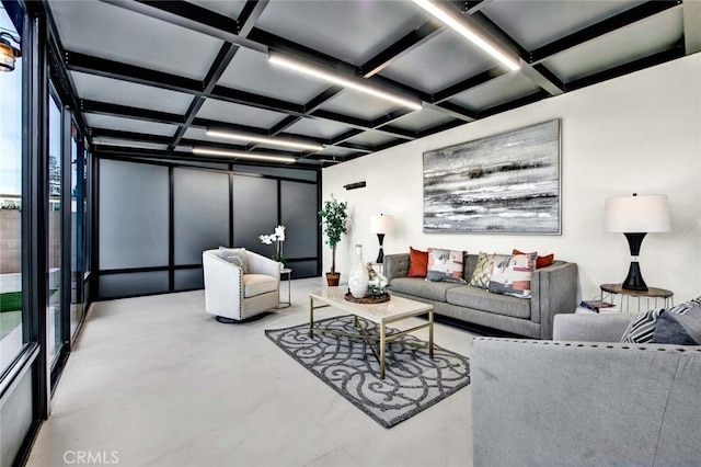 living area with concrete floors, coffered ceiling, and beam ceiling